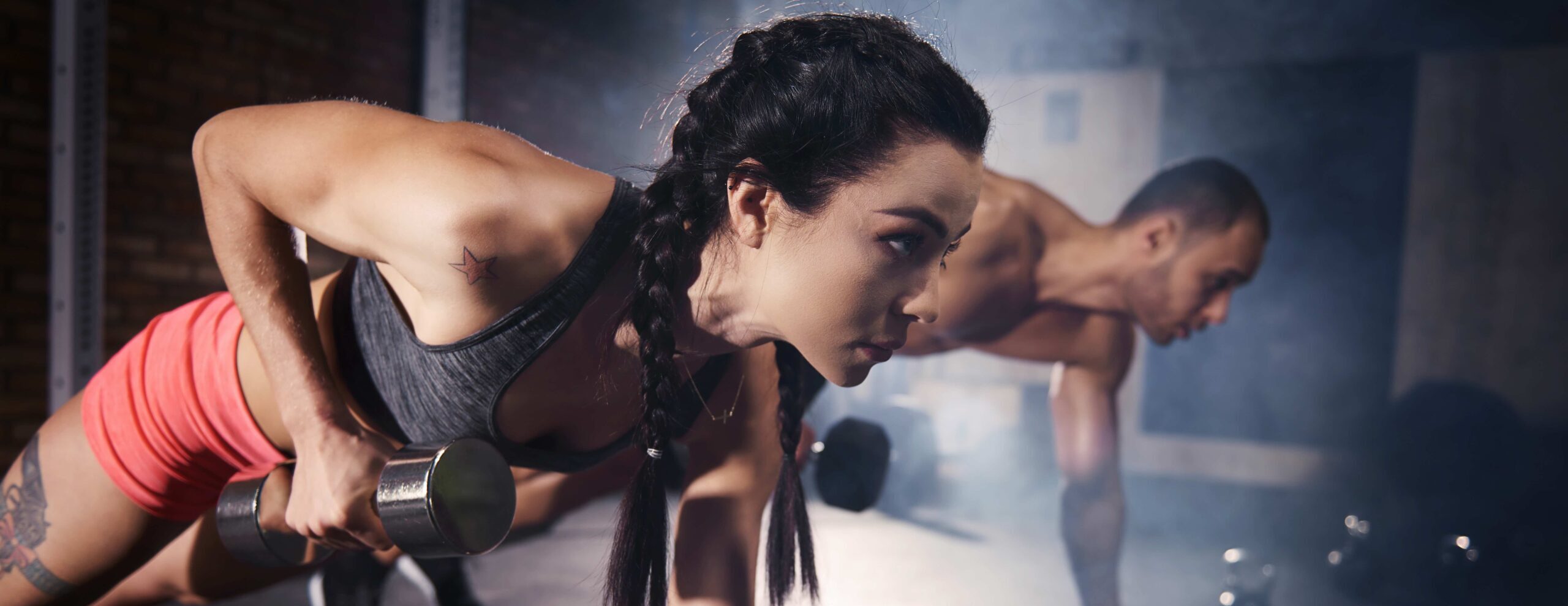 Confident couple working out with dumbbell